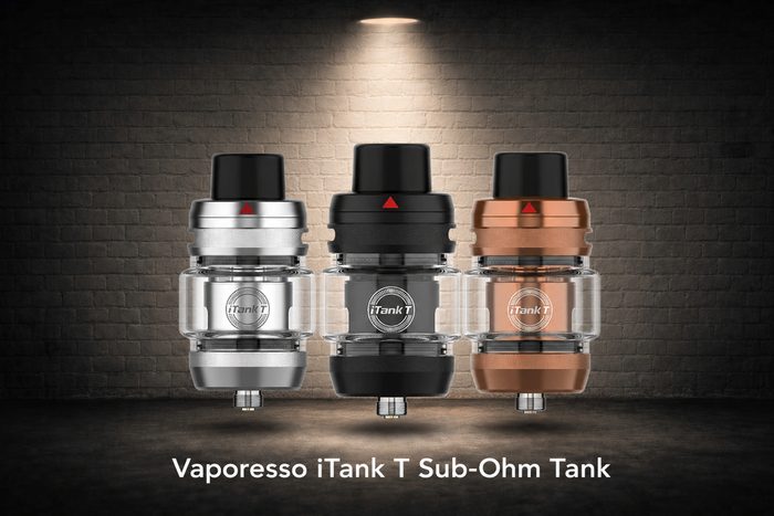 Three Vaporesso iTank T Sub-Ohm Tanks in silver, black, and bronze finishes displayed under a spotlight against a brick wall background.